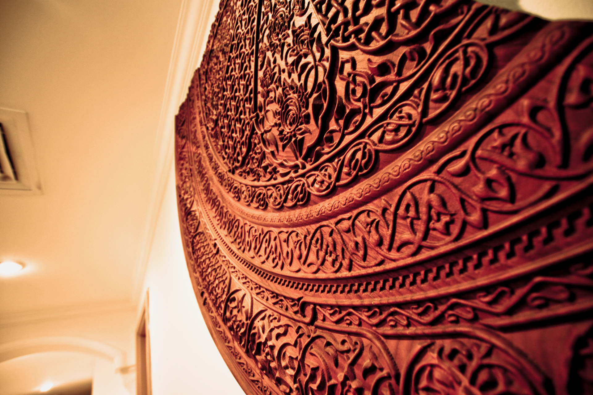 Ornate CNC carved circular wall art with intricate Arabic calligraphy and floral patterns in warm wood tones